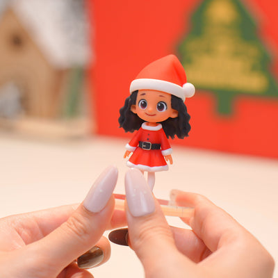 Hand holding a small Christmas-themed figurine with a blurred background