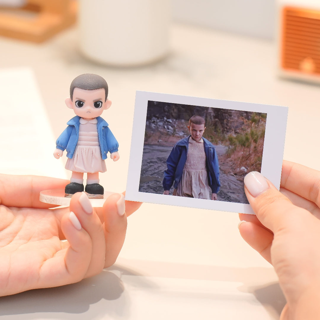 Person holding a figurine and a photo of a child in a natural setting