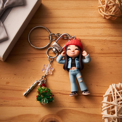 Keychain with a figurine of a person wearing a red hat and blue jacket on a wooden surface.