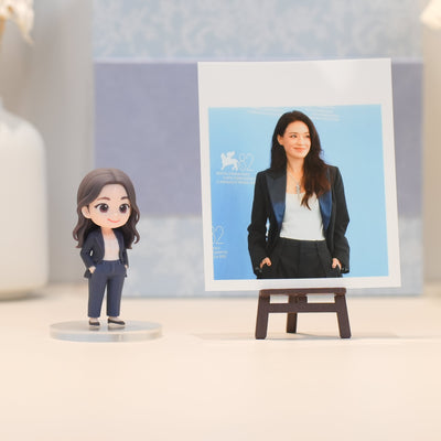 Figurine of a woman in a suit next to a photo of a woman on an easel