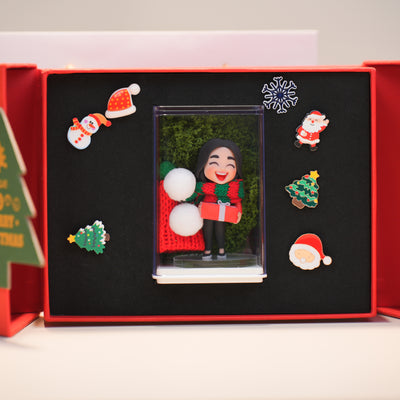 Decorative Christmas-themed figurine in a black box with festive decorations.