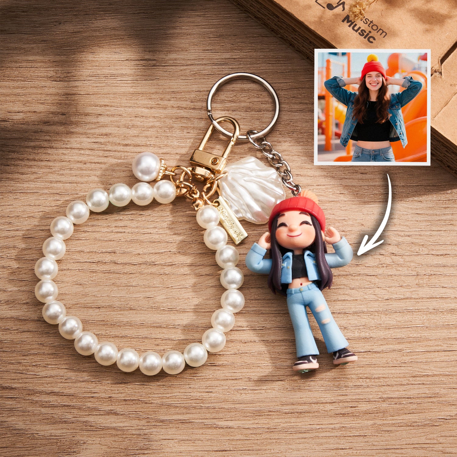 Pearl keychain with a small figurine of a person wearing a red hat and blue jeans on a wooden surface.
