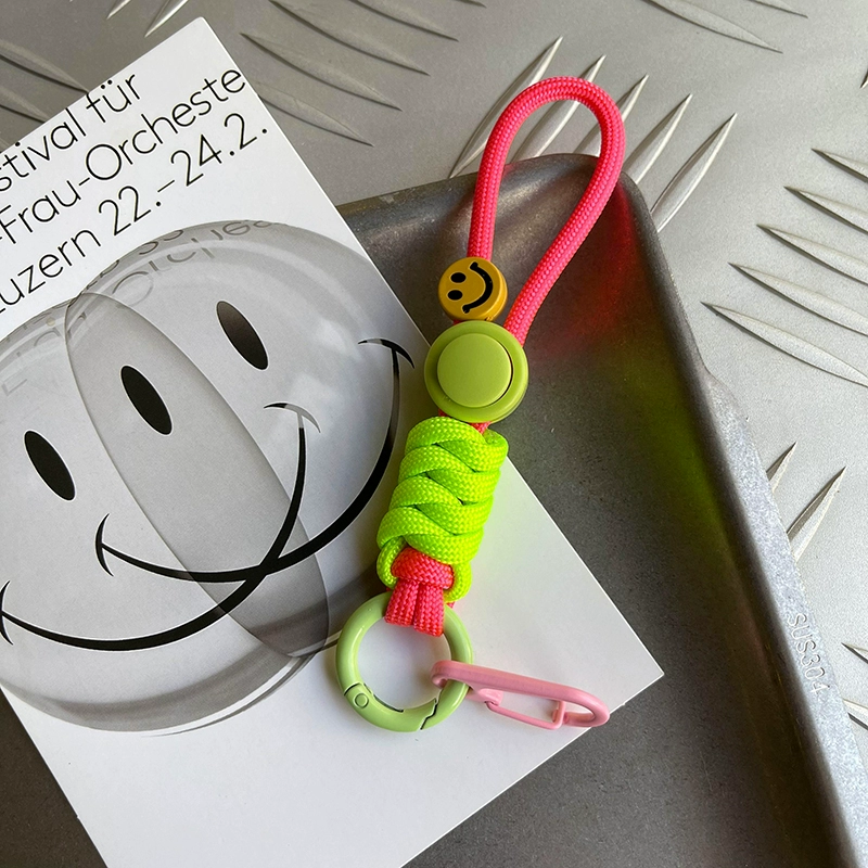 Colorful keychain with smiley face design on a metal surface