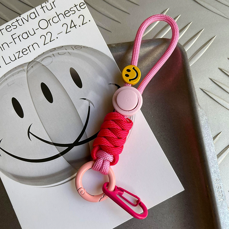 Pink keychain with smiley face charm on a magazine with smiley face design