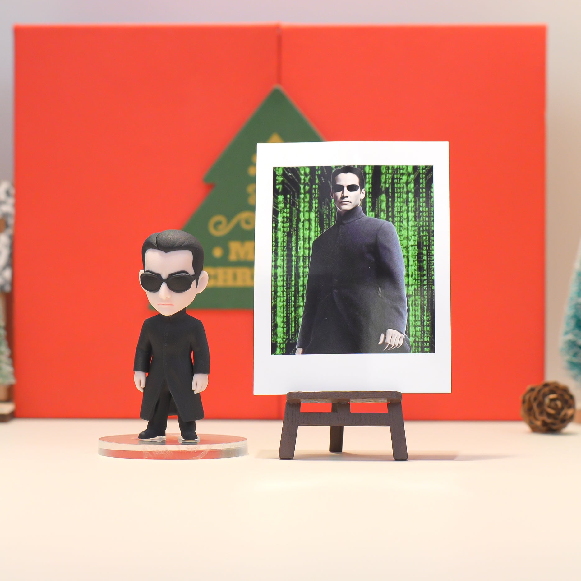 Action figure of a character from a movie with a screen displaying a famous scene, against a red and green background.