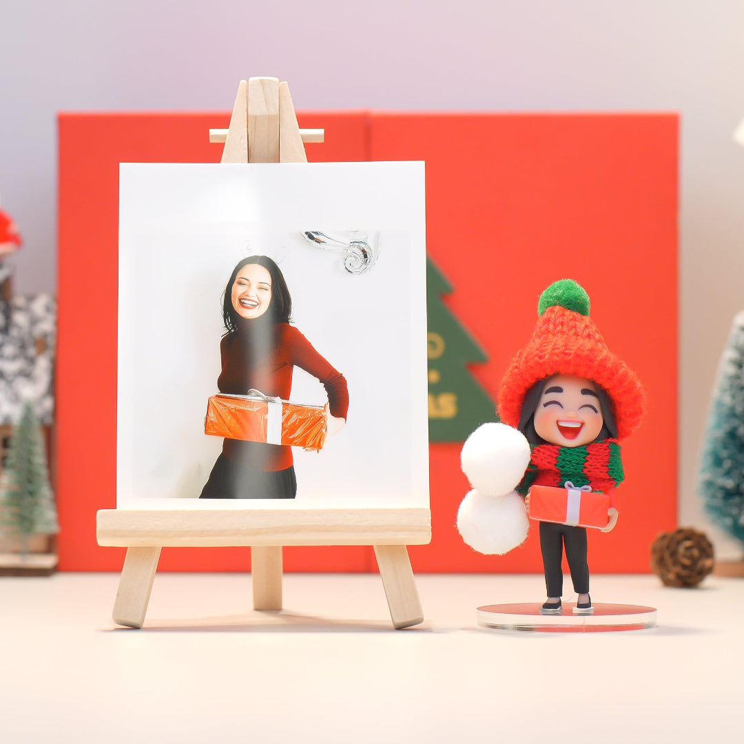 Christmas-themed figurine and photo on an easel with a red background