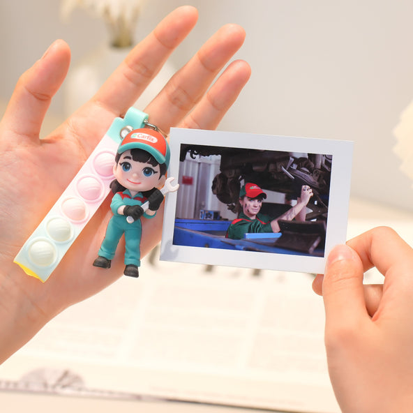 Person holding a keychain with a character and a photo of the same character on a card.