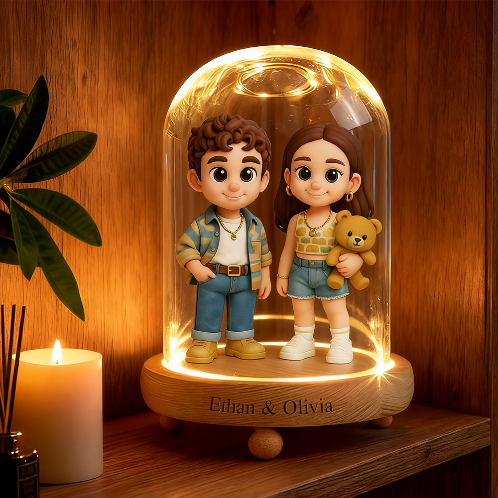 Two animated characters, a boy and a girl, inside a glass dome with a wooden base on a wooden shelf.