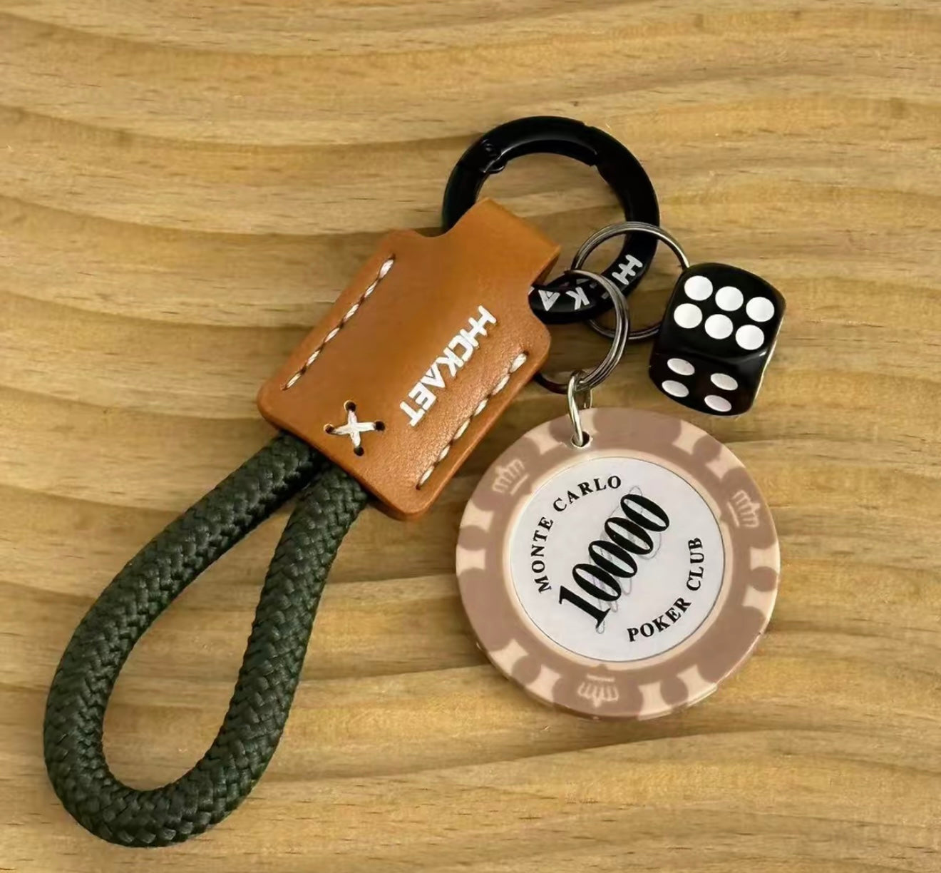 Keychain with poker chip, dice, and leather tag on a wooden surface