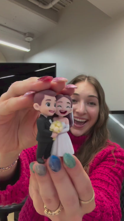 Creator holding a custom couple figurine of a bride and groom made from a photo