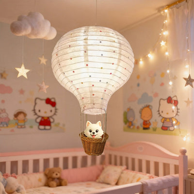Children's room with a lit paper hot air balloon toy above a crib